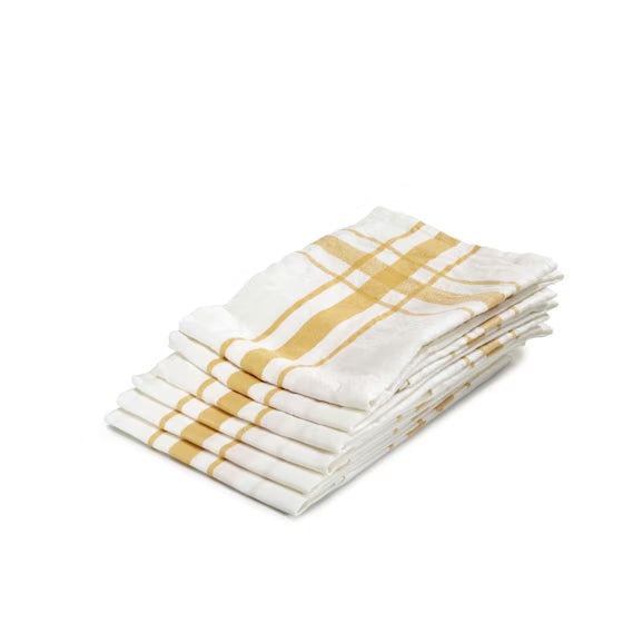 Stack of folded white tea towels with yellow stripes on a white background