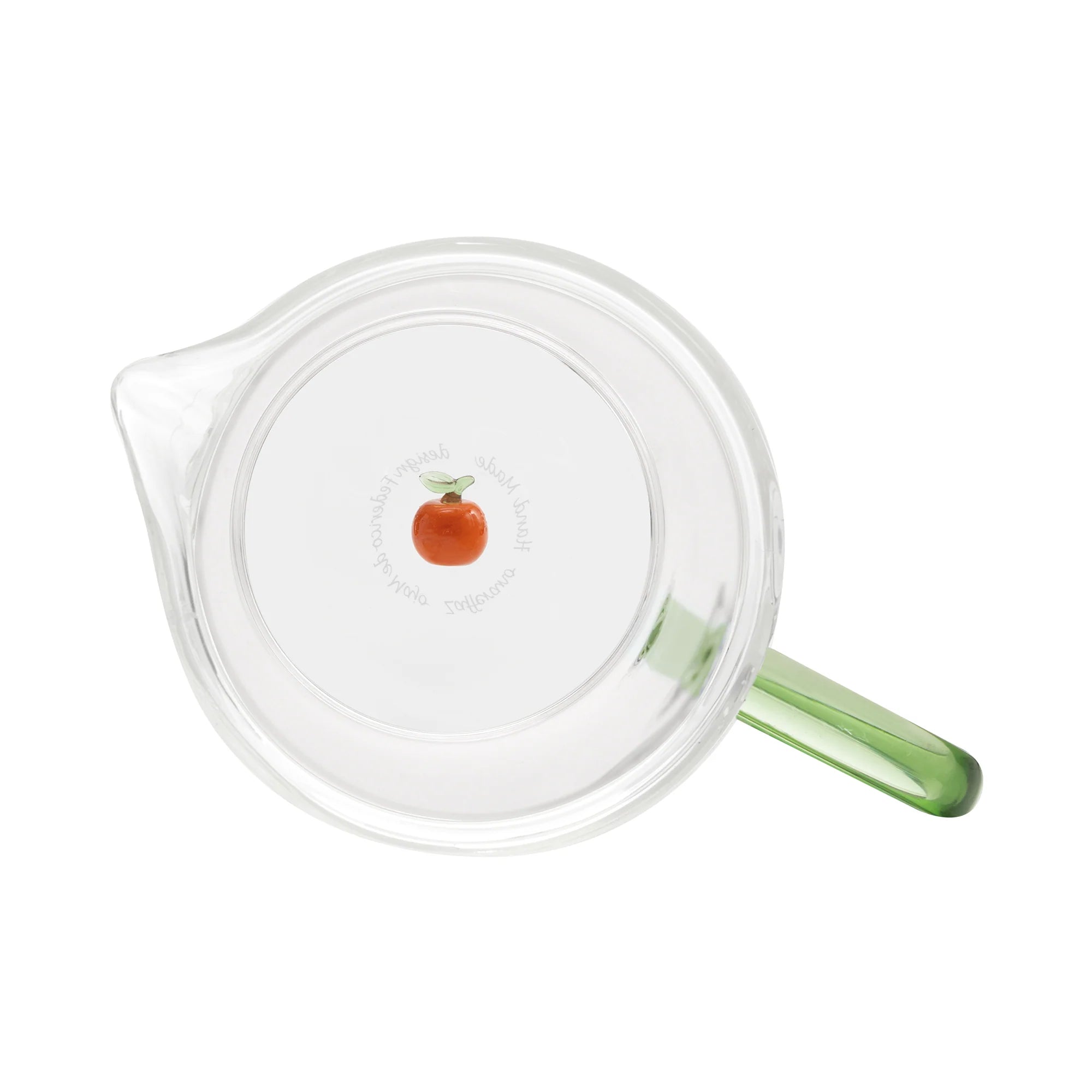 Clear glass carafe  with a green handle and an orange fruit design on a white background