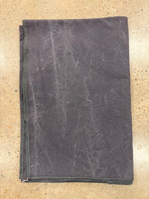 Folded gray blanket on a beige surface