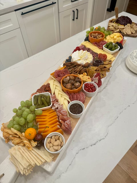 Charcuterie board with various foods on a kitchen counter