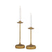 Two gold candle holders with white candles on a white background