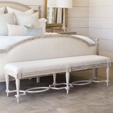 wood and upholstered french-style bench at foot of bed