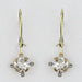 A pair of gold leverback earrings with clear round-cut gemstones in a four-prong setting, shown against a plain light gray background.