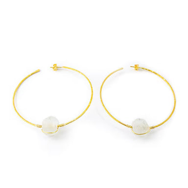 Gold hoop earrings with white spherical charms on a white background