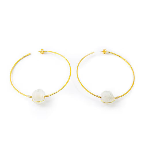 Gold hoop earrings with white spherical charms on a white background