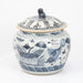 Blue and white ceramic jar with fish design on a white background