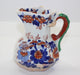 Decorative ceramic pitcher with floral patterns on a white background