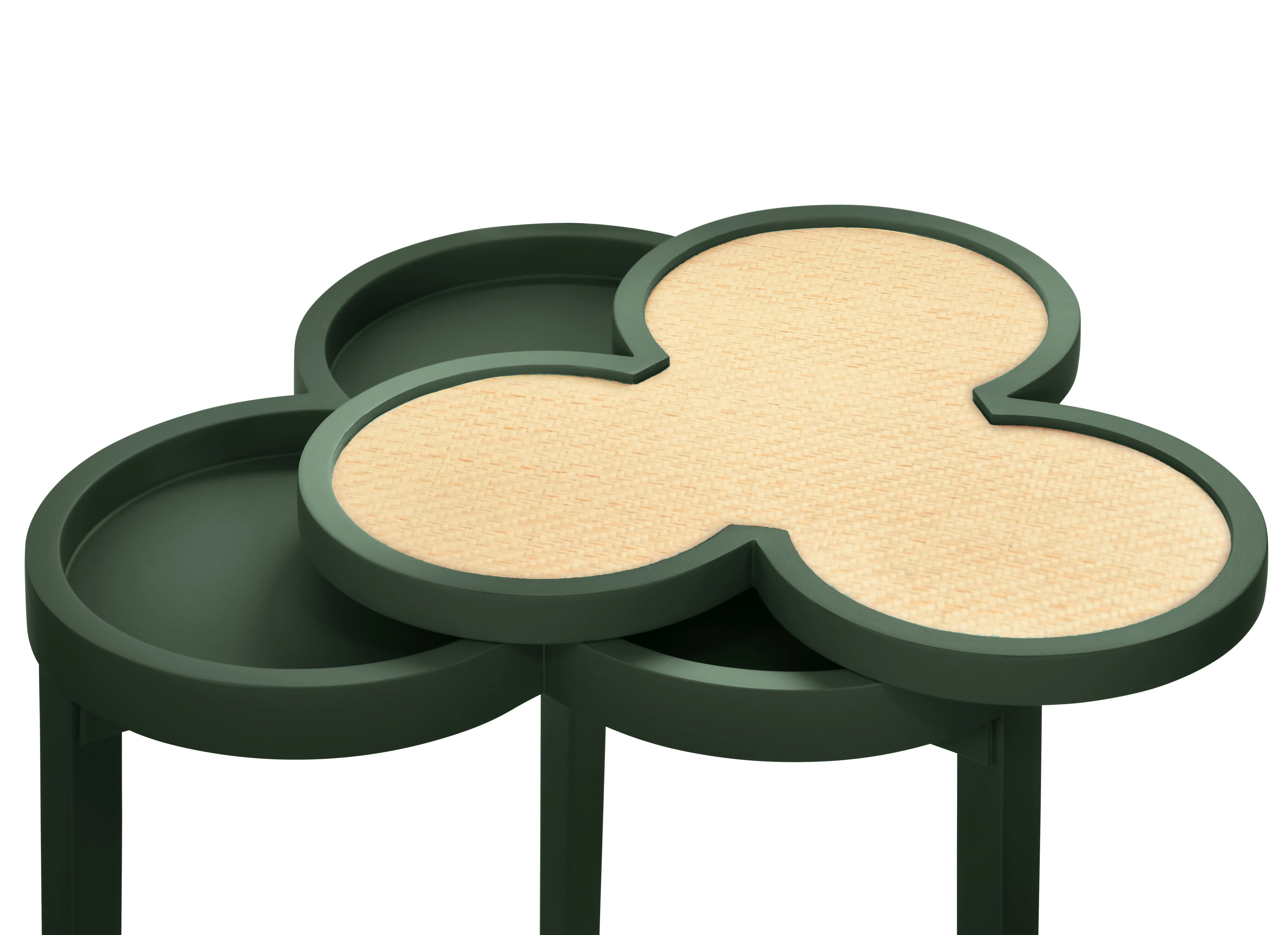 Green side table with green base and beige grasscloth top on a white background