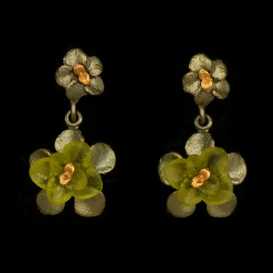 A pair of dangling flower earrings on a solid black background. Each earring features a textured metal top flower with a gold-tone center, and a larger hanging flower with translucent olive-green petals and a small gold-tone center.