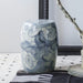 Decorative blue and white ceramic stool on a patterned rug with a neutral background