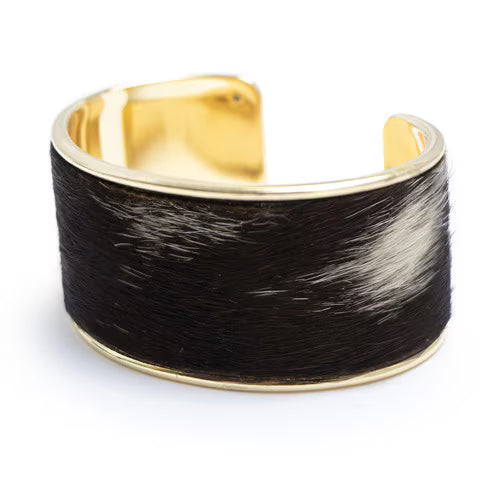 Gold and black fur cuff bracelet on a white background