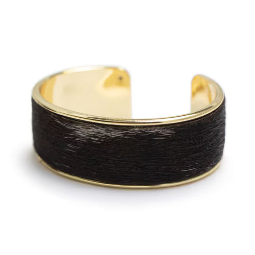 Gold and black hair-on-hide cuff bracelet on a white background