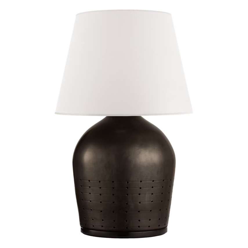Table lamp with a textured brown base and white shade on a black background