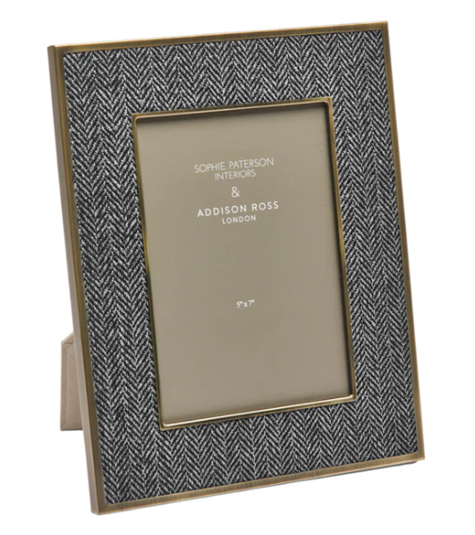 Herringbone patterned photo frame with gold trim on a white background