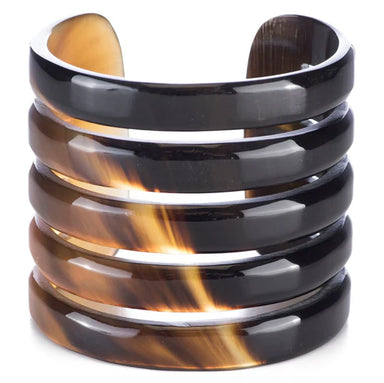 Stack of tortoiseshell and black horn bangles on a white background