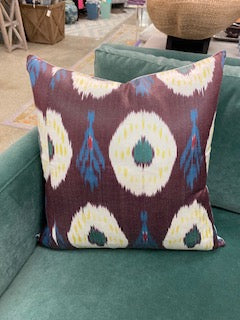 Decorative pillow with a colorful pattern on a teal couch