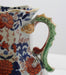 Ceramic pitcher with floral design on a white background