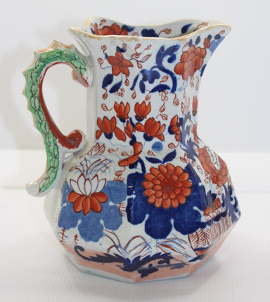 Decorative ceramic pitcher with floral patterns on a white background