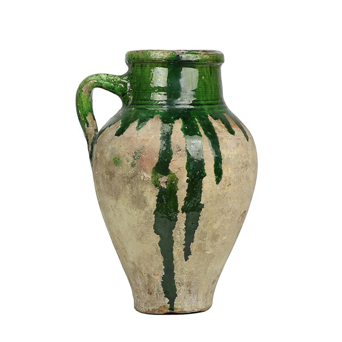 Vintage ceramic jar with green glaze on a white background