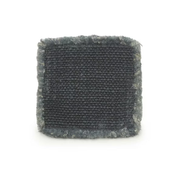 Square piece of textured black linen coaster fabric on a white background