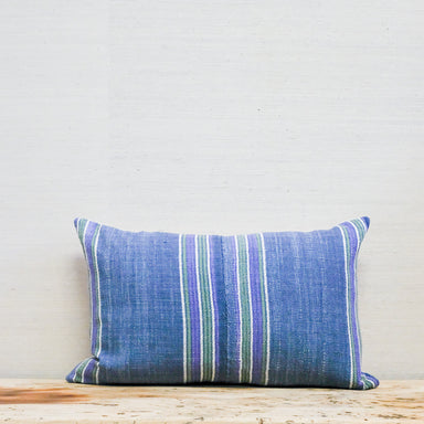 blue, green and purple stripe textile on oblong pillow