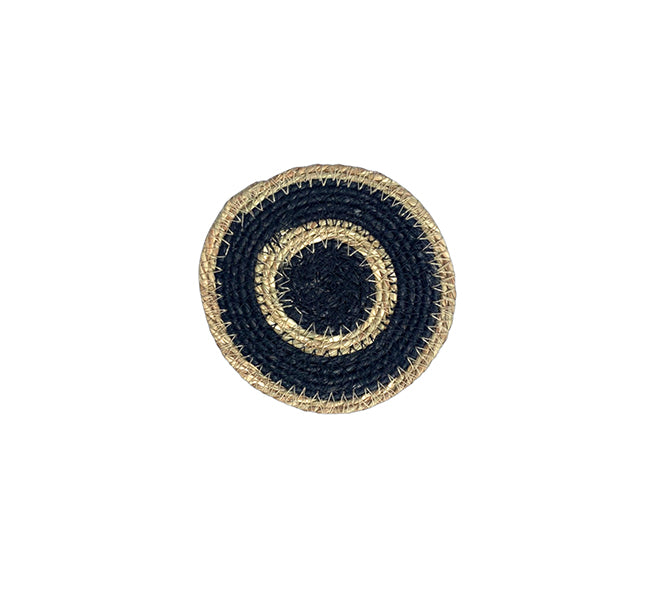 Round woven coaster with black and gold design on a white background