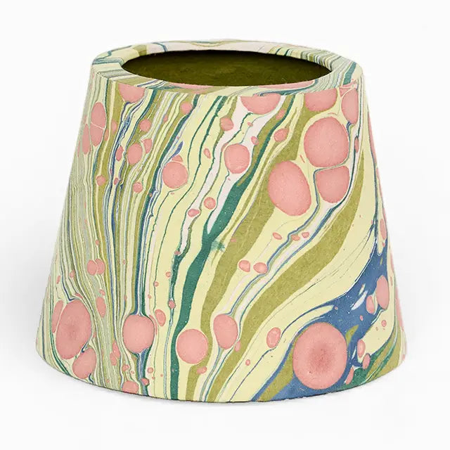 A small conical planter with a marbled pattern featuring pink circles, olive green and teal wavy stripes, and blue accents on a cream background, set against a plain white background.