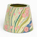 A small conical planter with a marbled pattern featuring pink circles, olive green and teal wavy stripes, and blue accents on a cream background, set against a plain white background.