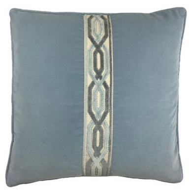 Blue velvet pillow with a decorative tape pattern on a white background