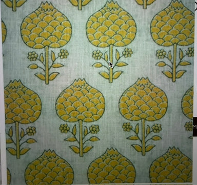 A close-up of a patterned fabric or wallpaper showing a repeating mid-century floral motif in mustard yellow and olive green on a pale sage green background.