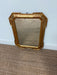 Gold-framed mirror on a carpeted floor with a light blue wall background