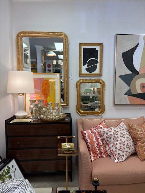 Living room with a couch, mirror, and artwork on a wall.