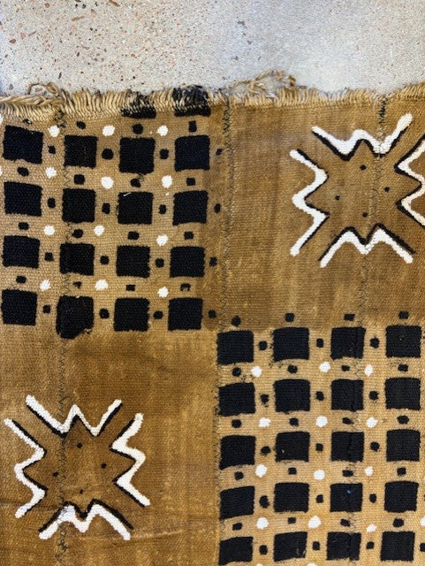 Textile with black and white geometric patterns on a beige background