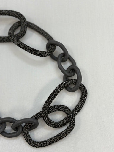 Black chain necklace on a light gray background