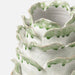 close up photo of edge detail of green and white ceramic vase