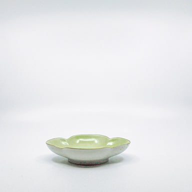 side view of white, gold, and green ceramic dish