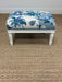  Ottoman with blue floral pattern on a brown carpet
