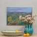 oil painting displayed with basket and vase of blush carnations