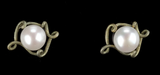 A pair of vintage-style pearl earrings with ornate, twisted gold-toned metal settings, displayed on a solid black background.