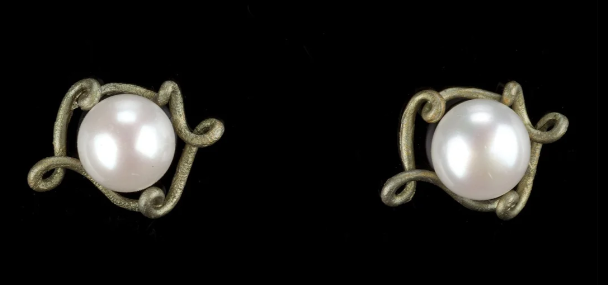 A pair of vintage-style pearl earrings with ornate, twisted gold-toned metal settings, displayed on a solid black background.