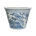 Blue and white ceramic planter with floral and bird design on a white background