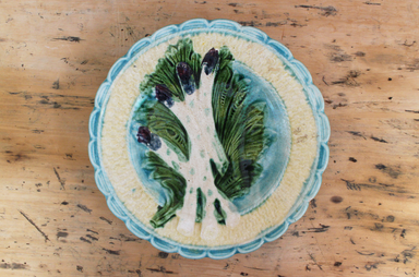 Decorative plate with asparagus design on a wooden surface