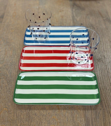 Set of three striped ceramic trays on a wooden surface