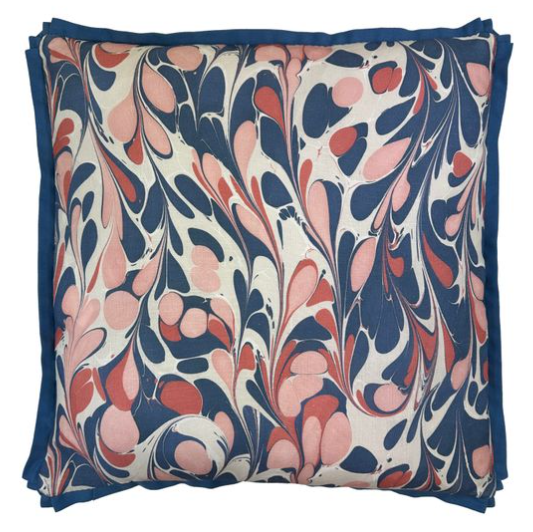 Linen pillow with a floral pattern in blue, pink, and white on a white background