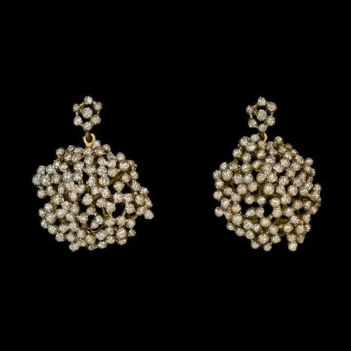 Pair of gold and pearl cluster  earrings on a black background