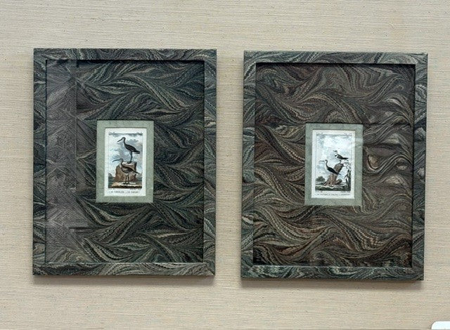 Two decorative wall frames with intricate patterns on a wooden surface.