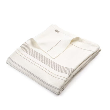 Folded beige coverlet with a brand logo on a white background