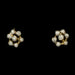 A pair of gold flower-shaped stud earrings set with small clear round gemstones, shown against a solid black background.