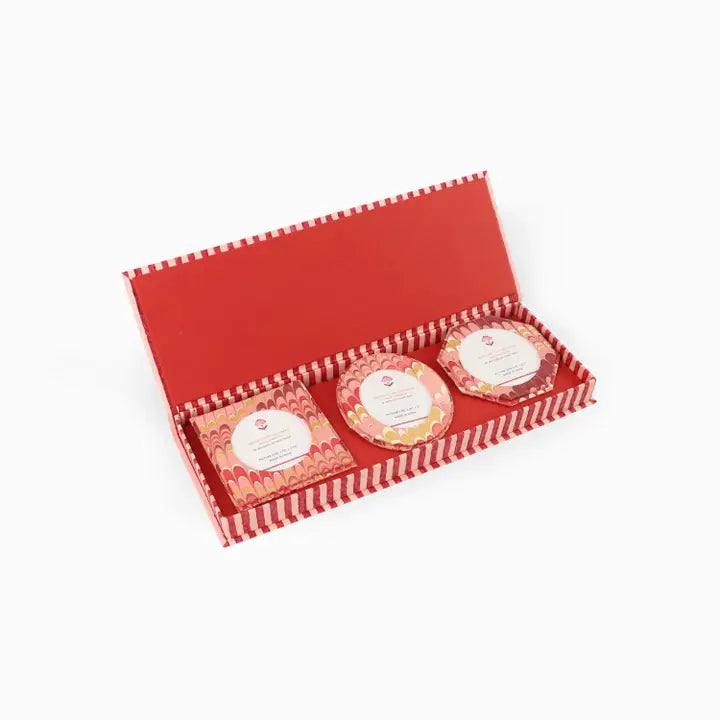 A red gift box with a striped border, shown open on a white background. Inside are three packaged round and rectangular frames with red and white marbled patterns and white labels.