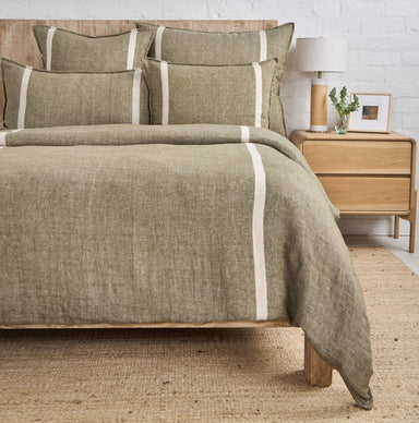 moss and flax textured duvet set on a bed with a wooden headboard and nightstand in a bedroom setting.